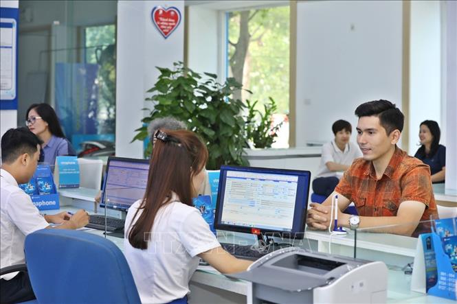 Trong ảnh: Khách đến giao dịch tại Trung tâm kinh doanh VNPT Hà Nội. Ảnh: Minh Quyết – TTXVN