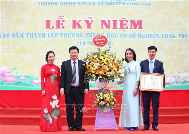 Trong ảnh: Thứ trưởng Bộ Giáo dục và Đào tạo tặng hoa chúc mừng Trường THCS Nguyễn Công Trứ kỷ niệm 100 năm thành lập. Ảnh: Thanh Tùng - TTXVN