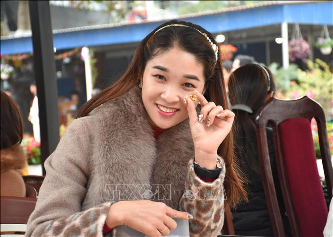 Trong ảnh: Chị Băng Nga ở thị trấn Yên Thế, huyện Lục Yên là một người có nhiều năm kinh nghiệm, gắn bó với chợ đá quý đang giới thiệu sản phẩm tại bàn của mình. Ảnh: Tuấn Anh-TTXVN