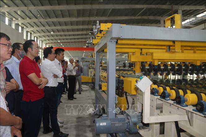 Photo: Delegates visit the production line in the factory. VNA Photo: Hoàng Nhị