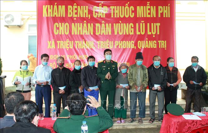 Trong ảnh: Cán bộ quân y Quân khu 4 tặng quà cho người dân xã Triệu Thành. Ảnh: Hồ Cầu - TTXVN