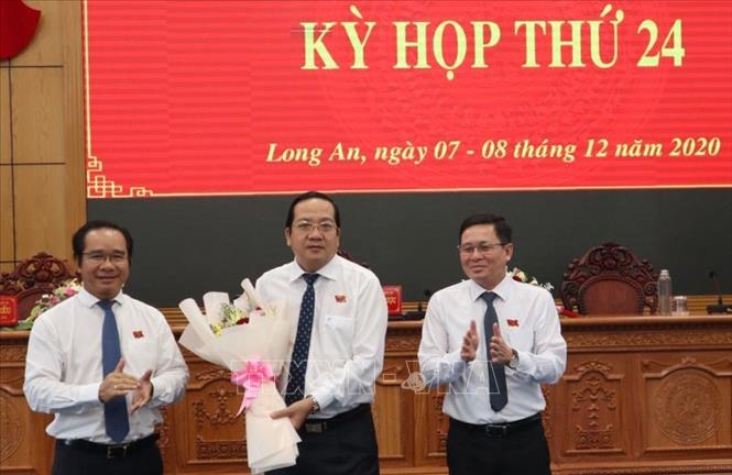 Bí thư Tỉnh ủy, Chủ tịch HĐND tỉnh Long An Nguyễn Văn Được (bìa trái), tặng hoa chúc mừng Phó Chủ tịch UBND Nguyễn Minh Lâm. Ảnh: Thanh Bình- TTXVN