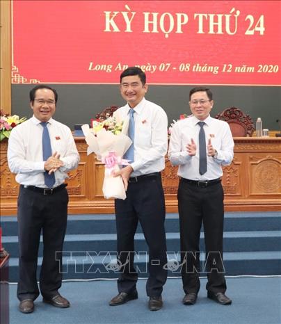 Bí thư Tỉnh ủy, Chủ tịch HĐND tỉnh Long An Nguyễn Văn Được (bìa trái), tặng hoa nguyên Phó Chủ tịch UBND tỉnh Phạm Văn Cảnh. Ảnh: Thanh Bình- TTXVN