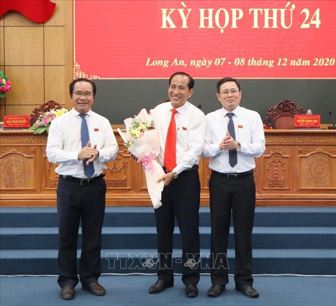 Bí thư Tỉnh ủy, Chủ tịch HĐND tỉnh Long An Nguyễn Văn Được (bìa trái), tặng hoa nguyên Phó Chủ tịch HĐND tỉnh Nguyễn Thanh Cang. Ảnh: Thanh Bình- TTXVN