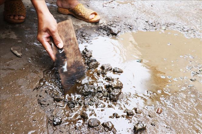 Trong ảnh: Mặt đường dù đã được trải nhựa nhưng nhiều chỗ sỏi cát vẫn bị bong tróc. Ảnh: Huỳnh Sử -  TTXVN 
