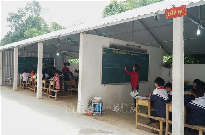 Từ nơi để xe đạp, nhà trường chuyển thành 4 phòng học tạm. Do các lớp quá gần nhau, không có cách âm nên thầy và trò không dám nói to vì sợ ảnh hưởng đến lớp học bên cạnh. Ảnh: Bích Huệ - TTXVN