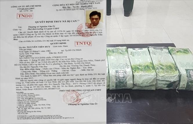 Trong ảnh: Quyết định truy nã đặc biệt Nguyễn Tiến Huy và tang vật là 4kg ma tuý bị Công an quận 4, thành phố Hồ Chí Minh bắt giữ. Ảnh: TTTXVN phát
