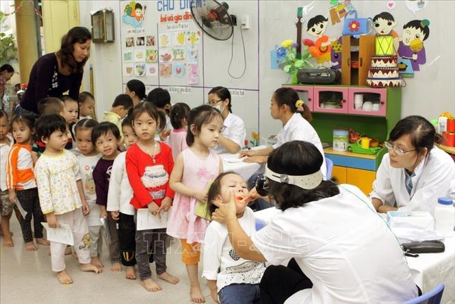 Đảng và Nhà nước ta luôn luôn xác định quyền con người là giá trị chung của nhân loại; con người vừa là mục tiêu, vừa là động lực của sự nghiệp xây dựng và bảo vệ đất nước; bảo đảm và thúc đẩy quyền con người là nhân tố quan trọng cho sự phát triển bền vững. Trong ảnh Nhân viên y tế quận Hai Bà Trưng khám kiểm tra sức khỏe sức khỏe định kỳ miễn phí cho trẻ em Trường mầm non Bạch Mai (Hà Nội). Ảnh Dương Ngọc – TTXVN