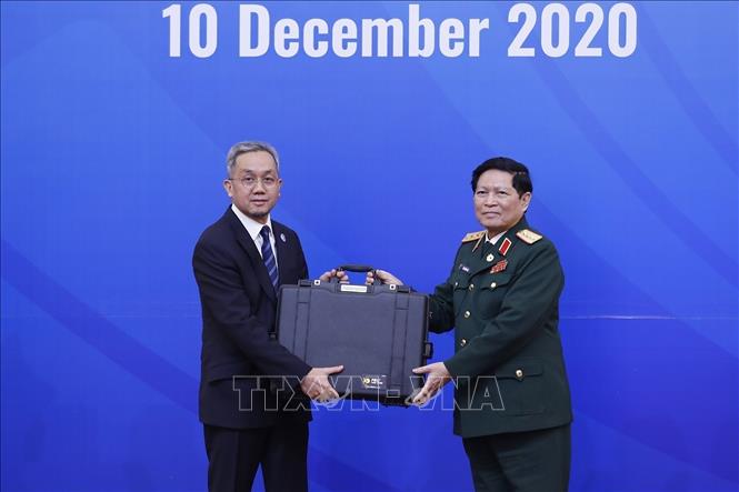 Photo: Defence Minister General Ngo Xuan Lich (R) hands over ADMM, ADMM+ symbols to Brunei Ambassador to Vietnam Dato Paduka Haji Mahadi bin Wasli. VNA Photo: Dương Giang