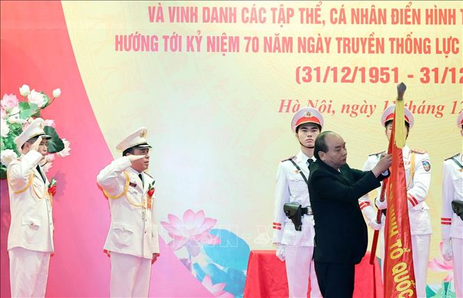 Thủ tướng Nguyễn Xuân Phúc gắn danh hiệu Anh hùng lực lượng vũ nhân dân lên lá cờ truyền thống của Cục An ninh điều tra, Bộ Công an. Ảnh: Thống Nhất – TTXVN