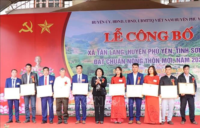 Bà Tráng Thị Xuân, Phó Chủ tịch Thường trực UBND tỉnh Sơn La tặng Bằng khen của Chủ tịch UBND tỉnh cho các cá nhân có thành tích xuất sắc trong thực hiện Chương trình mục tiêu quốc gia về xây dựng nông thôn mới trên địa bàn xã Tân Lang, huyện Phù Yên. Ảnh: Nguyễn Cường - TTXVN