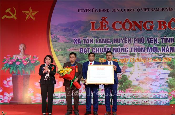 Bà Tráng Thị Xuân, Phó Chủ tịch Thường trực UBND tỉnh Sơn La trao Bằng công nhận đạt chuẩn nông thôn mới năm 2020 cho tập thể lãnh đạo xã Tân Lang, huyện Phù Yên. Ảnh: Nguyễn Cường - TTXVN.
