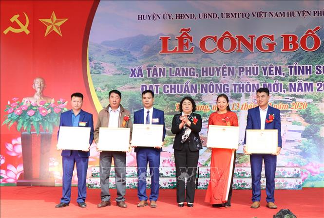 Bà Tráng Thị Xuân, Phó Chủ tịch Thường trực UBND tỉnh Sơn La tặng Bằng khen của Chủ tịch UBND tỉnh cho các tập thể có thành tích xuất sắc trong thực hiện Chương trình mục tiêu quốc gia về xây dựng nông thôn mới trên địa bàn xã Tân Lang, huyện Phù Yên. Ảnh: Nguyễn Cường - TTXVN.