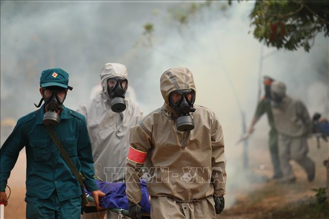 Trong ảnh: Lực lượng Bộ đội hoá học và lực lượng cứu nạn tại chỗ đưa người bị nạn rời hiện trường. Ảnh: Dương Giang - TTXVN