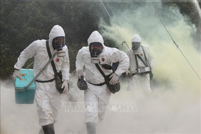 Trong ảnh: Lực lượng Bộ đội hoá học cơ động tiếp cận hiện trường. Ảnh: Dương Giang - TTXVN