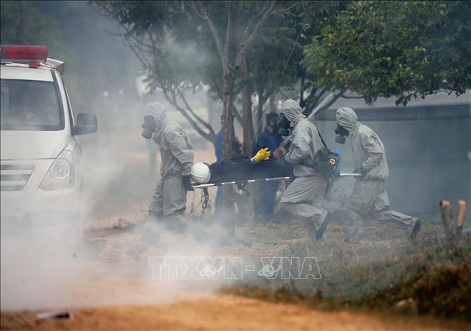Trong ảnh: Lực lượng Bộ đội hoá học đưa người bị nạn rời hiện trường. Ảnh: Dương Giang - TTXVN