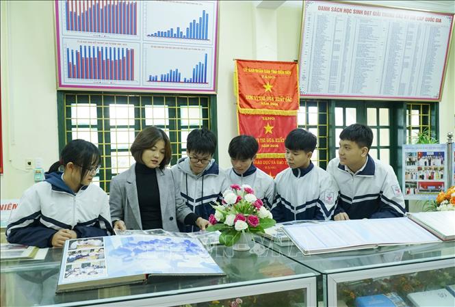 Trong ảnh: Giáo viên và học sinh thăm quan phòng truyền thống của nhà trường. Ảnh: Xuân Tư – TTXVN