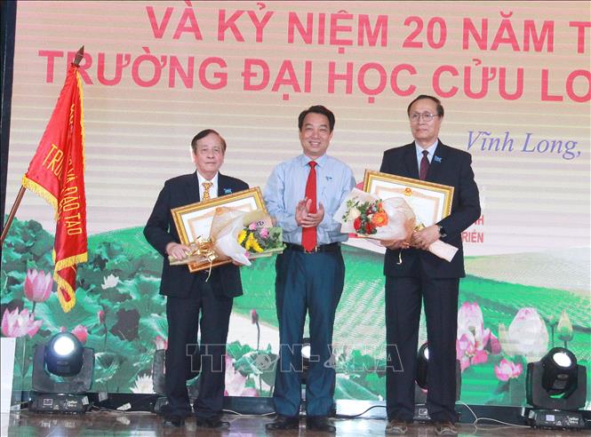 Trong ảnh: Trao Bằng khen của Thủ tướng Chính phủ cho các ông Nguyễn Cao Đạt và Nguyễn Thanh Dũng, Phó Hiệu trưởng Trường Đại học Cửu Long. Ảnh: Lê Thúy Hằng – TTXVN