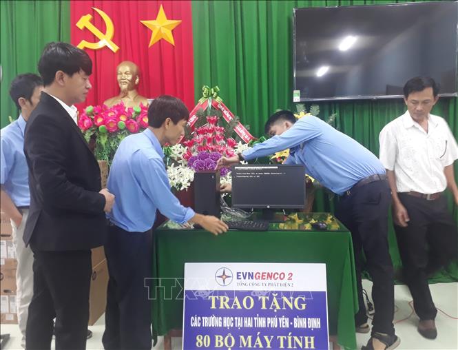 Trong ảnh: Các nhân viên Điện lực Bình Định lắp đặt máy tính cho các trường học được Tổng công ty Phát điện 2 trao tặng. Ảnh: Tường Quân - TTXVN
