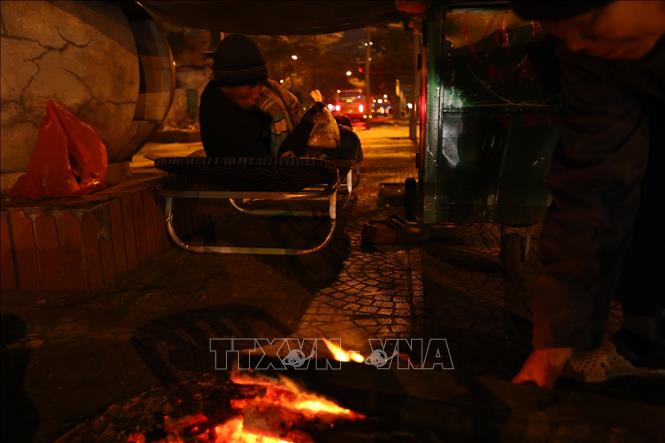Trong ảnh: Người dân đốt lửa sưởi ấm trên phố Yên Phụ. Ảnh: Hoàng Hiếu - TTXVN 