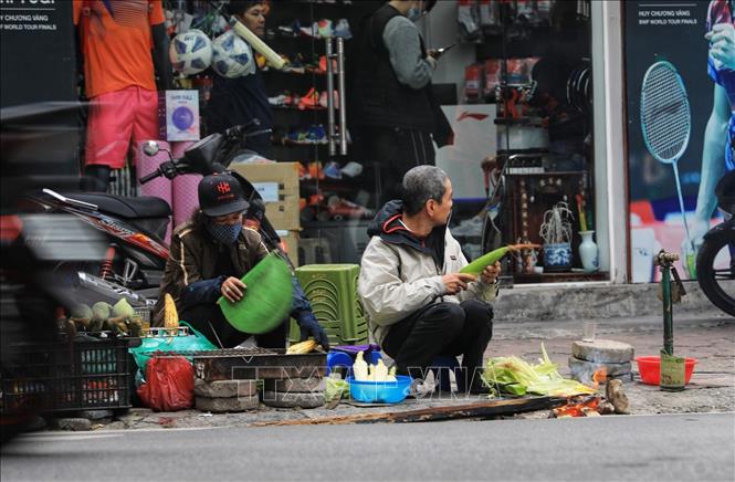 Trong ảnh: Các hàng bán ngô nướng chính là nơi sưởi ấm lý tưởng cho người dân. Ảnh: Thành Đạt - TTXVN 
