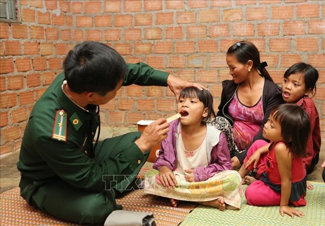 Trong ảnh: Cán bộ quân y của đồn Biên phòng Cửa khẩu quốc tế Bờ Y, huyện Ngọc Hồi (Kon Tum) thăm khám và cấp phát thuốc cho trẻ em có hoàn cảnh khó khăn. Ảnh: Dương Giang - TTXVN
