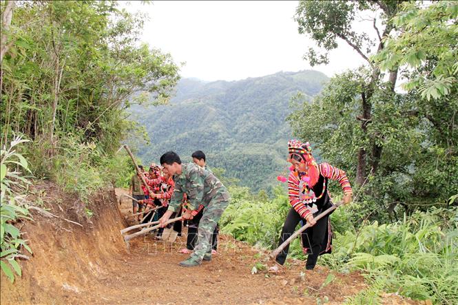 Trong ảnh: Cán bộ, chiến sỹ Bộ đội Biên phòng Lai Châu cùng bà con nhân dân mở đường vào bản. Ảnh: Công Tuyên-TTXVN