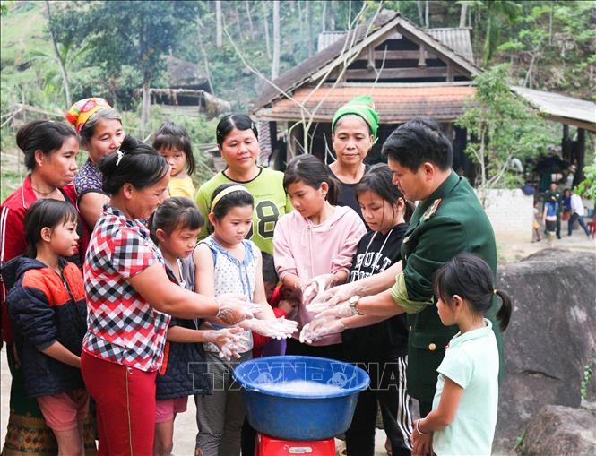 Trong ảnh: Bộ đội biên phòng đồn Hạnh Dịch, huyện Quế Phong (Nghệ An) hướng dẫn bà con cách rửa tay phòng chống dịch COVID 19. Ảnh: Nguyễn Oanh-TTXVN.