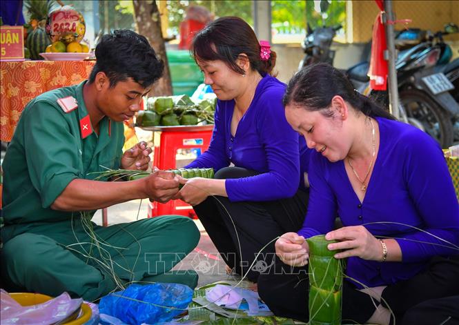 Trong ảnh: Các chiến sĩ thuộc Bộ Chỉ huy Quân sự tỉnh Kiên Giang cùng nhân dân tham gia Hội thi gói, nấu bánh tét Ảnh: Lê Sen - TTXVN