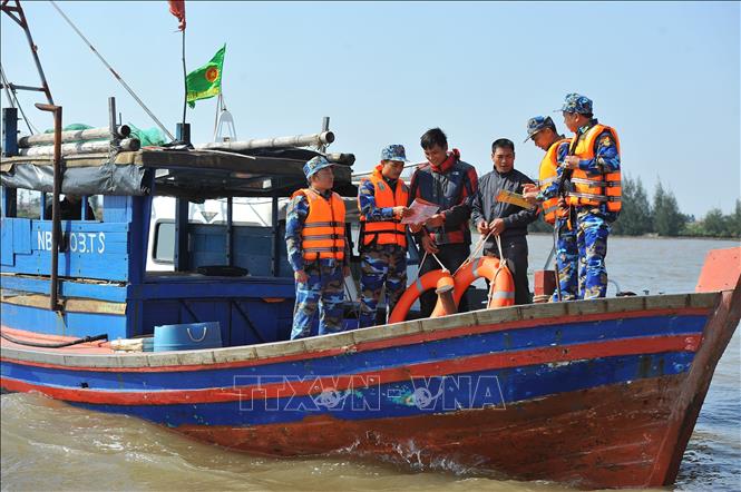 Trong ảnh: Cán bộ chiến sĩ Hải đội 2 (Ninh Bình) tuyên truyền, phổ biến, giáo dục pháp luật cho nhân dân và phát áo phao cho ngư dân ở khu vực biên giới biển. Ảnh: Minh Đức – TTXVN