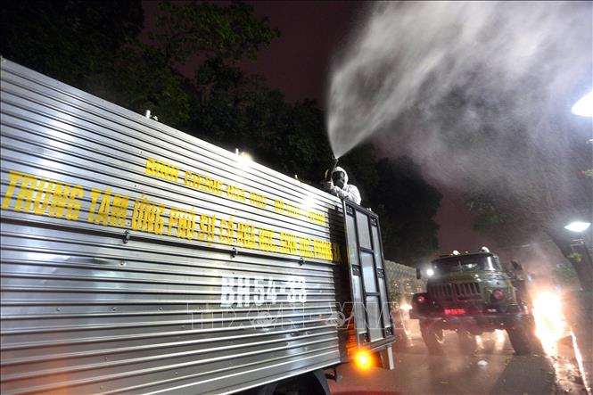 Trong ảnh: Lực lượng bộ đội hóa học với xe chuyên dụng tiến hành phun hóa chất tẩy độc, khử trùng Bệnh viện Bạch Mai sau khi phát hiện nhiều trường hợp dương tính với virus SARS-COV-2 có liên quan đến Bệnh viện. Ảnh: Dương Giang - TTXVNN