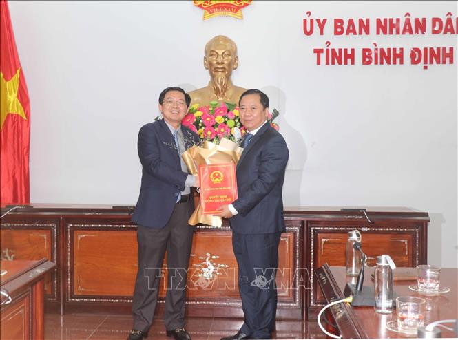 Trong ảnh: Thừa ủy quyền của Thủ tướng Chính phủ, ông Hồ Quốc Dũng – Bí thư Tỉnh ủy, Chủ tịch HĐND tỉnh Bình Định (trái) trao quyết định của Thủ tướng Chính phủ cho ông Nguyễn Phi Long, Chủ tịch UBND tỉnh Bình Định. Ảnh: Phạm Kha – TTXVN.