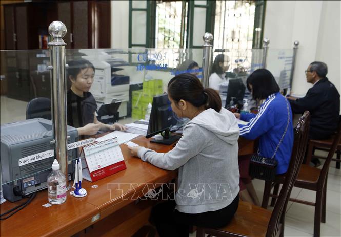 Trong ảnh: Nhân viên Bảo hiểm xã hội tỉnh Hưng Yên hướng dẫn người dân làm thủ tục tham gia Bảo hiểm xã hội. Ảnh: Phạm Kiên - TTXVN