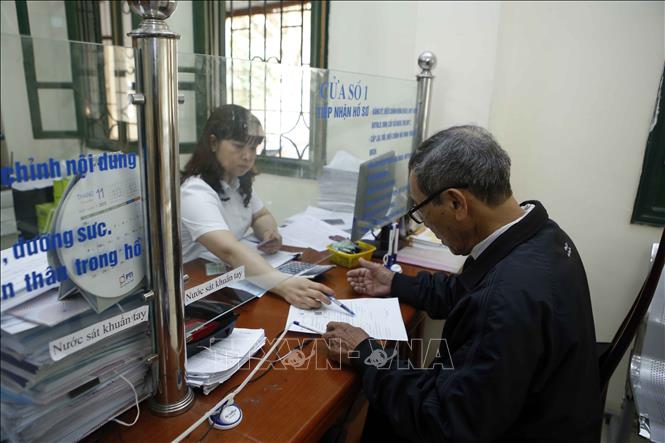 Trong ảnh: Nhân viên Bảo hiểm xã hội tỉnh Hưng Yên hướng dẫn người dân làm thủ tục tham gia Bảo hiểm xã hội. Ảnh: Phạm Kiên - TTXVN