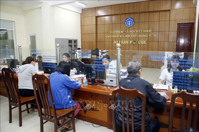Trong ảnh: Nhân viên Bảo hiểm xã hội tỉnh Hưng Yên hướng dẫn người dân làm thủ tục tham gia Bảo hiểm xã hội. Ảnh: Phạm Kiên - TTXVN