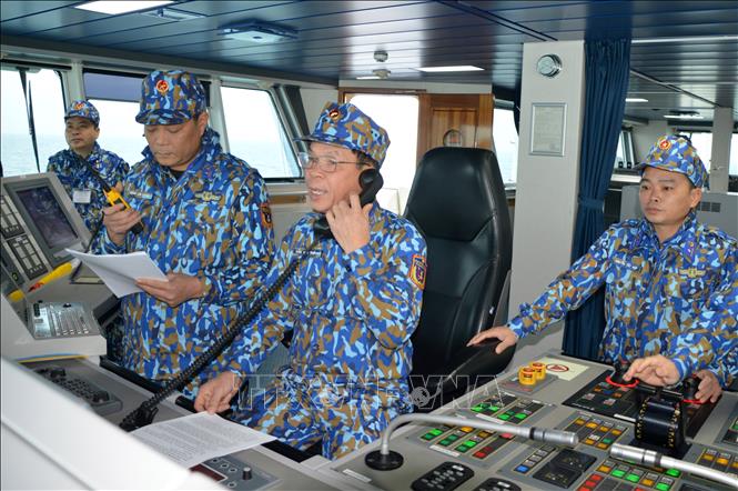 Photo: Colonel Tran Van Tho, Deputy Commander - Chief of Staff of the Coast Guard Region 1 Command uses a walkie-talkie to give a courtesy salute to Chinese force during the patrol./.