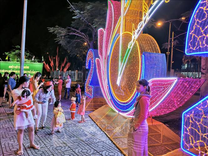 Người dân chụp ảnh trước biểu tượng năm 2021 trước cổng UBND thành phố. Ảnh: Thanh Liêm - TTXVN