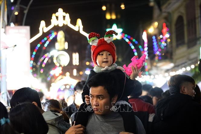 Trong ảnh: Niềm vui của một em bé khi được bố đưa đi chơi Giáng sinh. Ảnh: Tuấn Đức - TTXVN