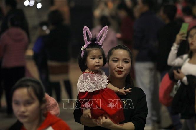 Trong ảnh: Hai mẹ con đón mừng Giáng sinh tại nhà thờ Sở Kiện. Ảnh: Phan Tuấn Anh - TTXVN