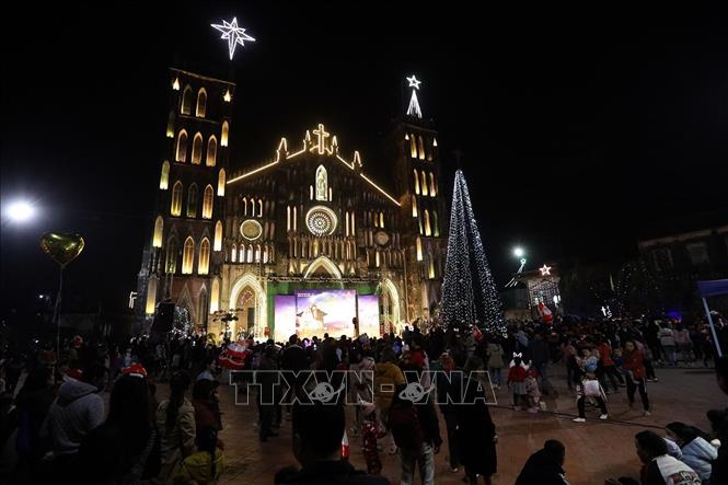 Trong ảnh: Giáo dân và du khách đến đón mừng Giáng sinh tại nhà thờ Sở Kiện. Ảnh: Phan Tuấn Anh - TTXVN