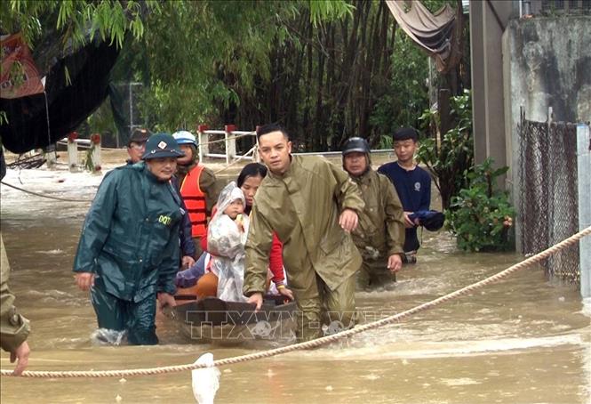 Trong ảnh: Cán bộ, chiến sĩ Công an thành phố Huế hỗ trợ di dời người dân ở vùng ngập sâu do mưa lũ đến nơi an toàn. Ảnh: TTXVN 