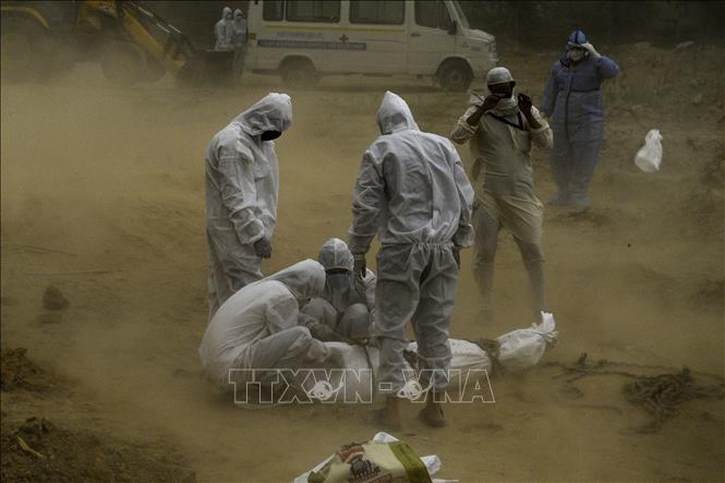 Trong ảnh: Chôn cất thi thể bệnh nhân COVID-19 tại một nghĩa trang ở New Delhi, Ấn Độ ngày 10/5/2020. Ảnh: AFP/TTXVN