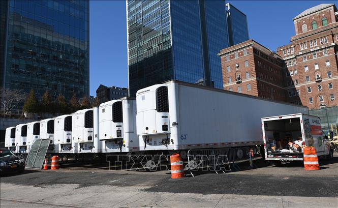 Trong ảnh: Các xe tải đông lạnh được sử dụng làm nhà xác dã chiến bên ngoài một bệnh viện ở New York, Mỹ, trong bối cảnh số bệnh nhân tử vong do COVID-19 tăng cao ngày 27/3/2020. Ảnh: AFP/TTXVN