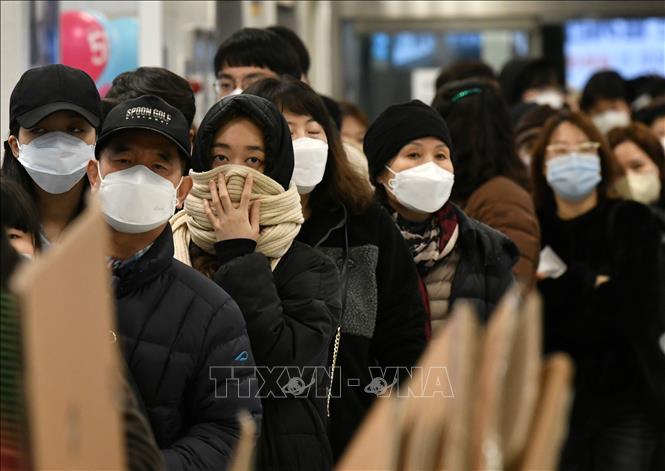 Trong ảnh: Người dân đeo khẩu trang phòng dịch COVID-19 khi xếp hàng bên ngoài một cửa hàng bán lẻ ở Daegu, Hàn Quốc ngày 25/2/2020. Ảnh: AFP/TTXVN