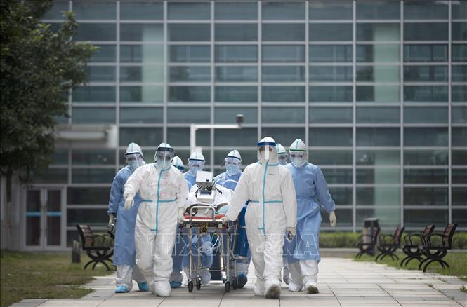 Trong ảnh: Nhân viên y tế chuyển bệnh nhân COVID-19 tại một bệnh viện ở Vũ Hán, Trung Quốc ngày 6/3/2020. Ảnh: THX/TTXVN