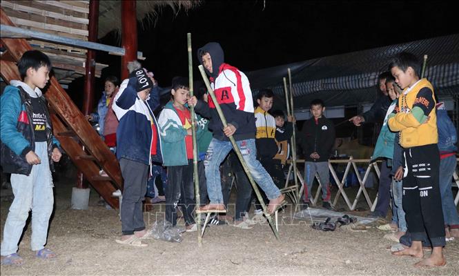 Trong ảnh: Học sinh tham gia trò chơi đi cà kheo trong lễ hội. Ảnh: Nguyễn Oanh - TTXVN