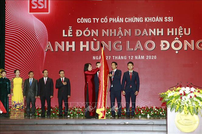 Trong ảnh: Phó Chủ tịch nước Đặng Thị Ngọc Thịnh gắn danh hiệu Anh hùng Lao động thời kỳ đổi mới lên cờ truyền thống của Công ty Cổ phần Chứng khoán SSI. Ảnh: Thanh Vũ - TTXVN