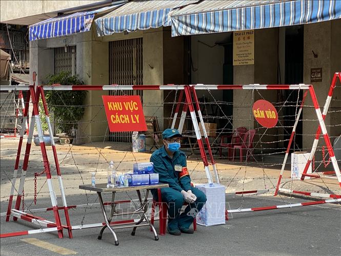 Trong ảnh: Lực lượng dân phòng khu vực túc trực để hỗ trợ những hộ dân trong khu cách ly . Ảnh: Hồng Giang - TTXVN.
