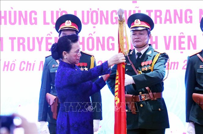 Trong ảnh: Chủ tịch Quốc hội Nguyễn Thị Kim Ngân gắn danh hiệu Anh hùng Lực lượng vũ trang nhân dân lên lá cờ truyền thống Bệnh  viện Quân y 175. Ảnh: Xuân Khu-TTXVN.