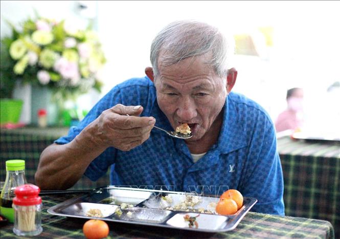 Trong ảnh: Người có hoàn cảnh khó khăn đến ăn cơm miễn phí tại Nhà ăn không đồng Nhất Tâm. Ảnh: Lê Ngọc Phước-TTXVN